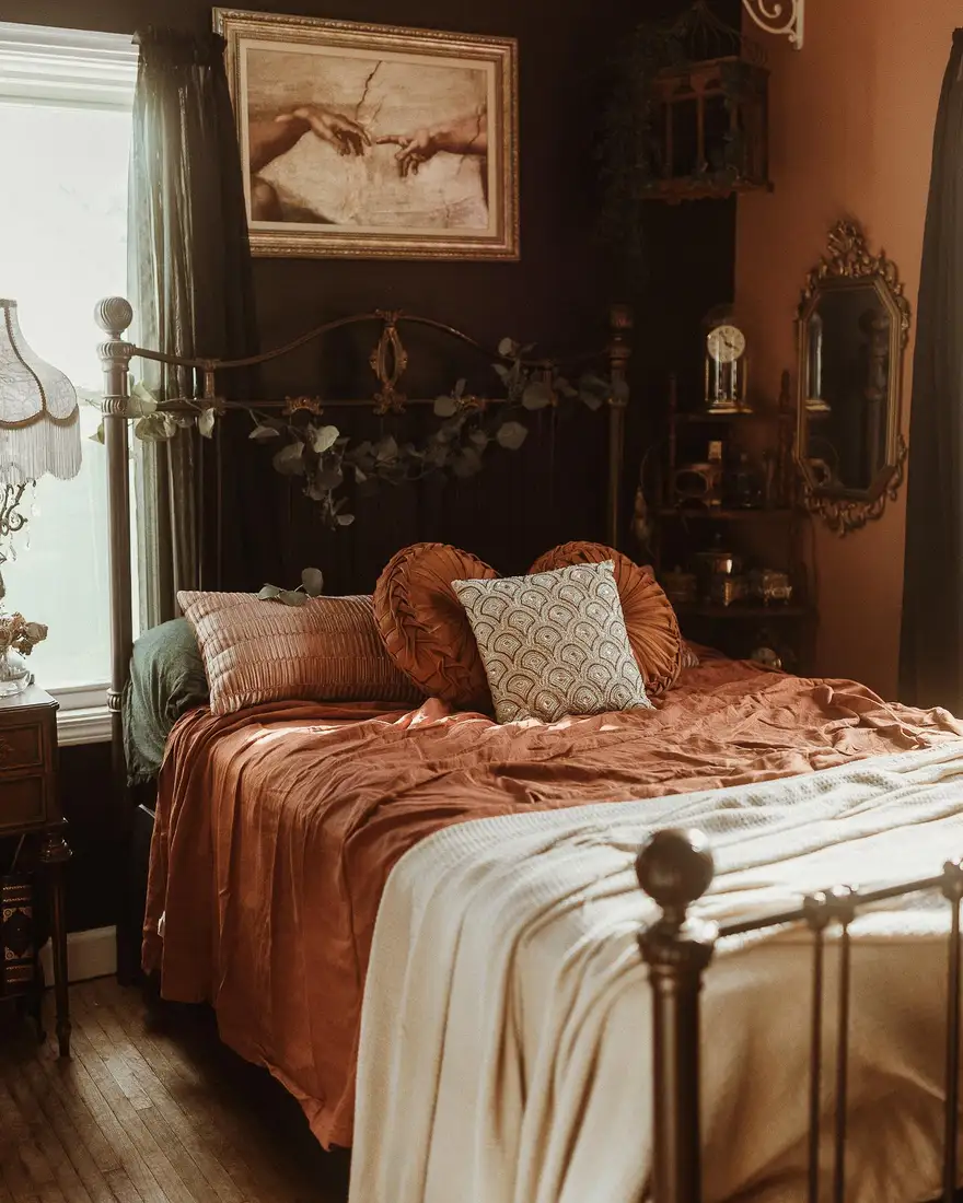 Warm brown bedroom with rust bedding, cream throw, vintage artwork and metal bed frame