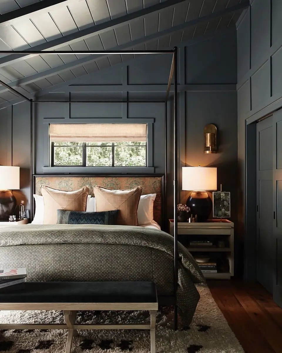 Dark blue attic bedroom with wall panel molding, canopy bed and sloped ceiling