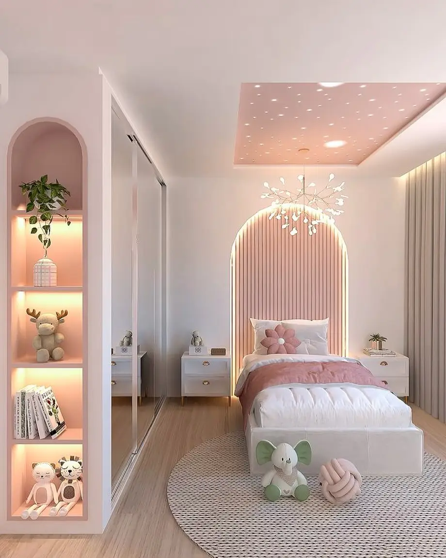 Modern pink girls bedroom with illuminated arched headboard, ceiling lights, built-in shelves, and mirrored wardrobe