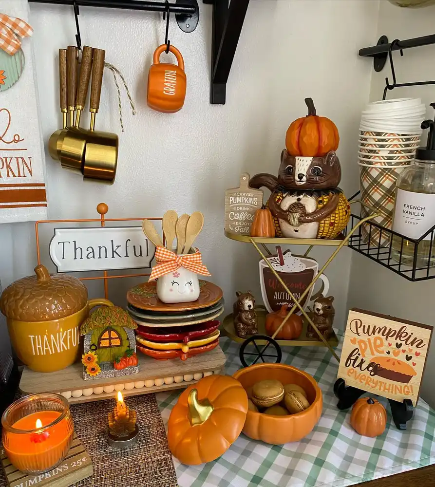 Playful fall coffee station with a pumpkin-shaped treat bowl, acorn container, and small woodland decorations