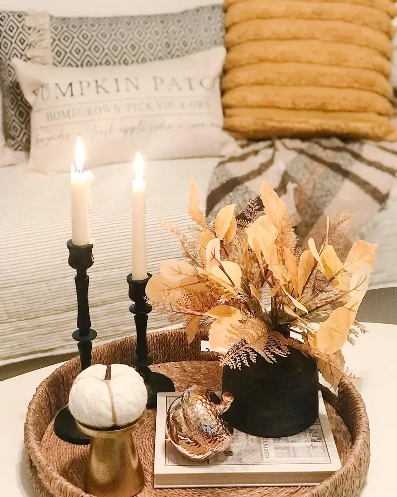 Fall coffee table tray with black candlesticks, a dark vase, pale leaves, white pumpkin, and warm metallic accents