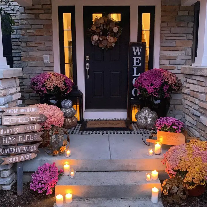 Front door with pink flowers in planters and glowing pathway lights along the walkway