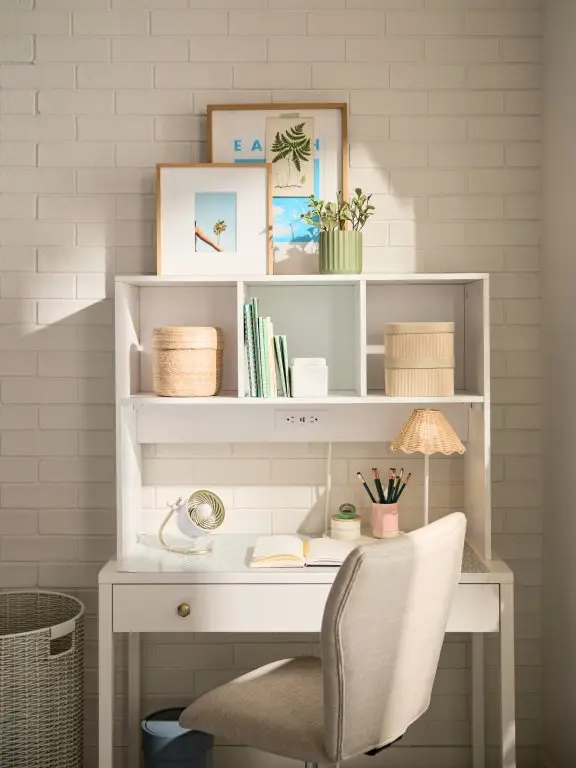 White dorm desk with hutch storage, books, baskets, decor, and open writing space