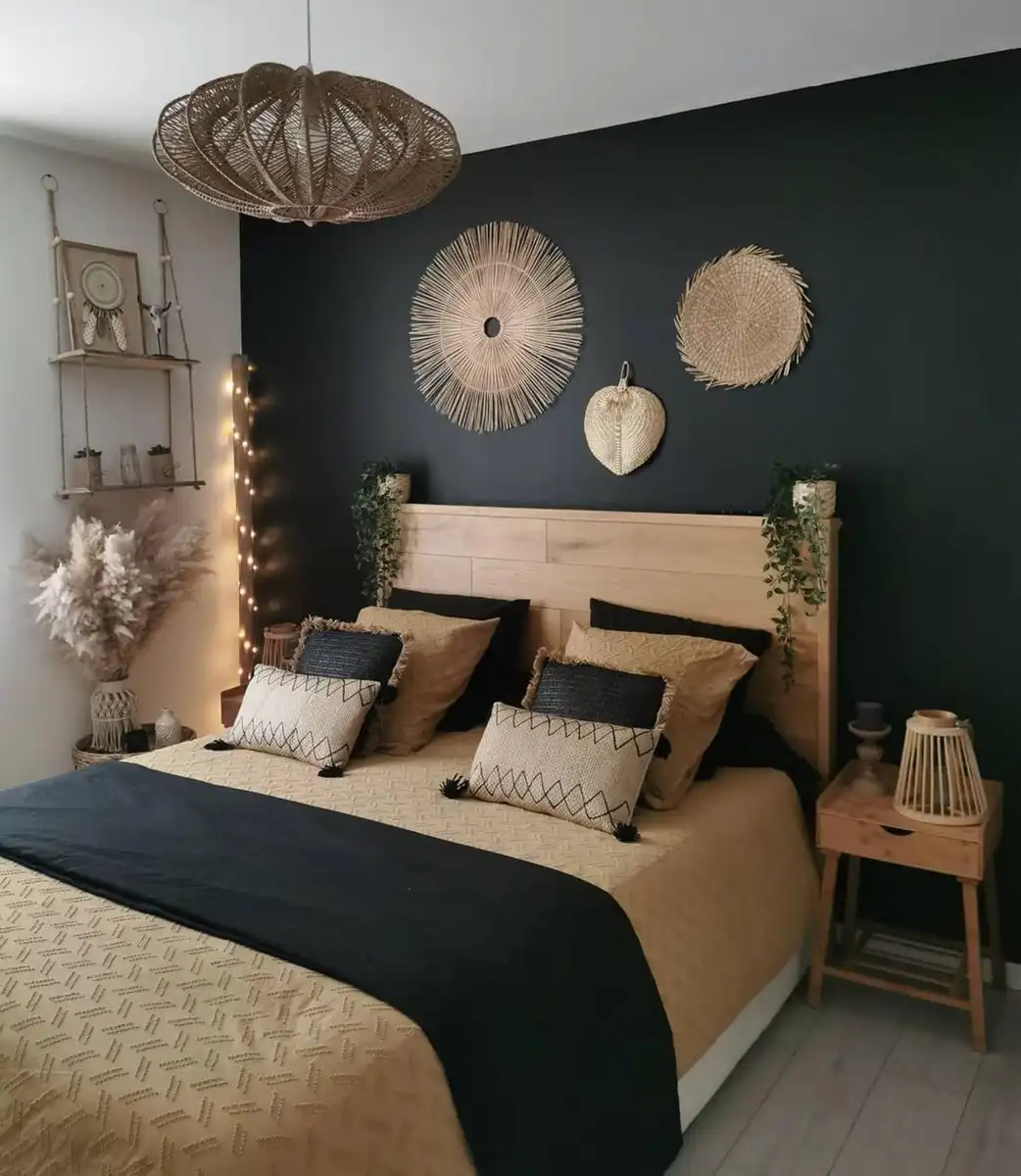 Dark boho bedroom with one black accent wall, light wood bed, woven wall decor, tan bedding, and slim bedside tables