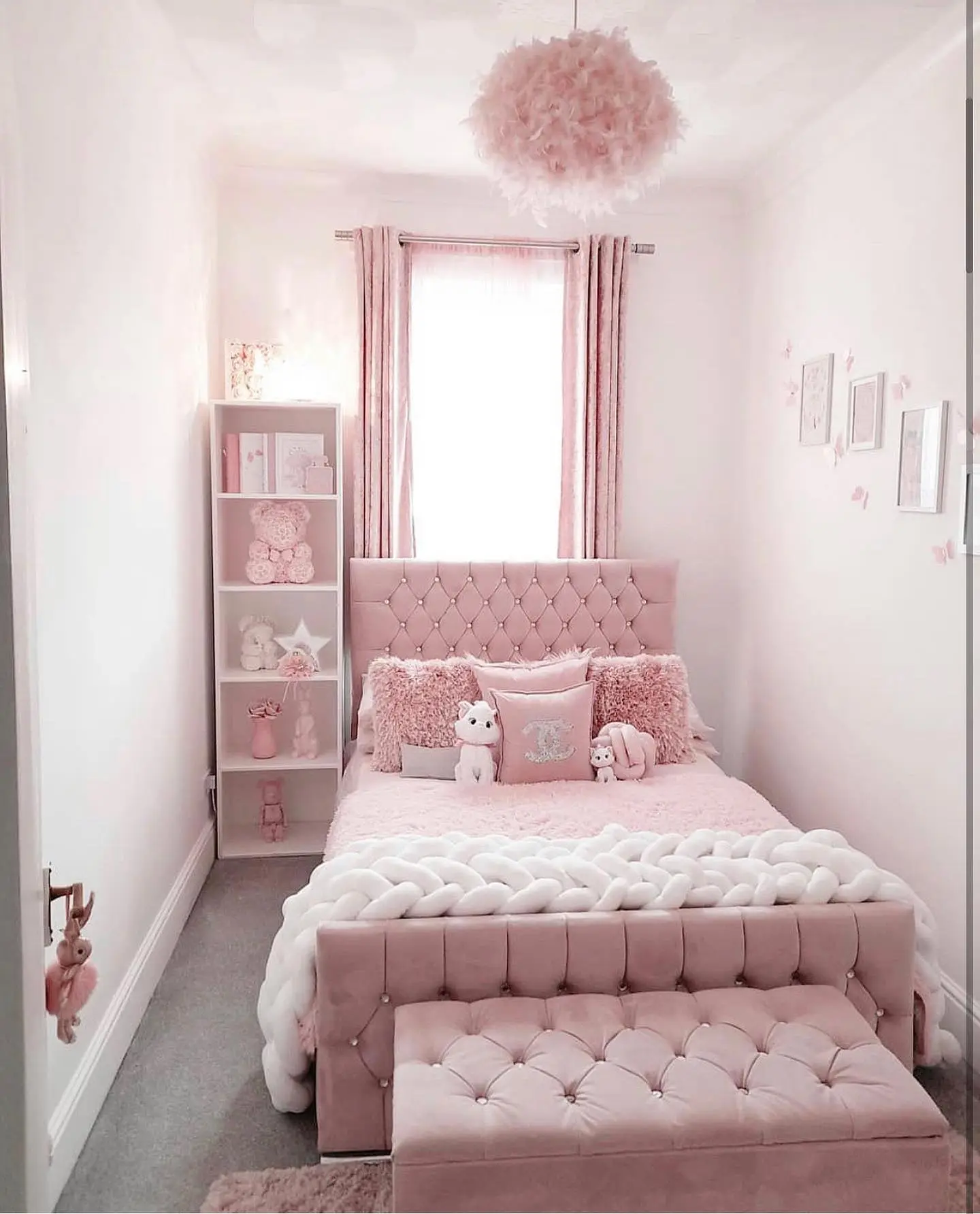 Pink small kids bedroom with upholstered bed, matching curtains, bench, and storage unit