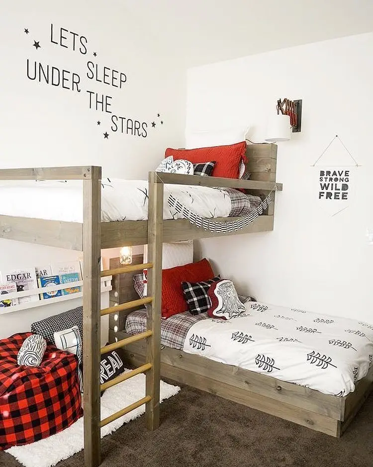 Kids bedroom with L-shaped wooden bunk beds, reading chair, and book storage