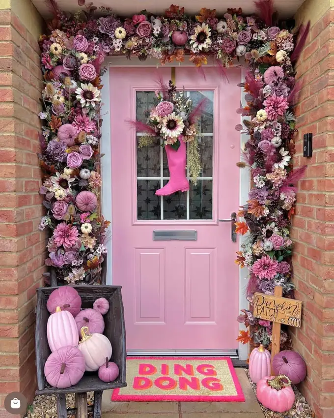 Pink front door decorated with colorful balloons, a pink-themed party display, and flower arrangements