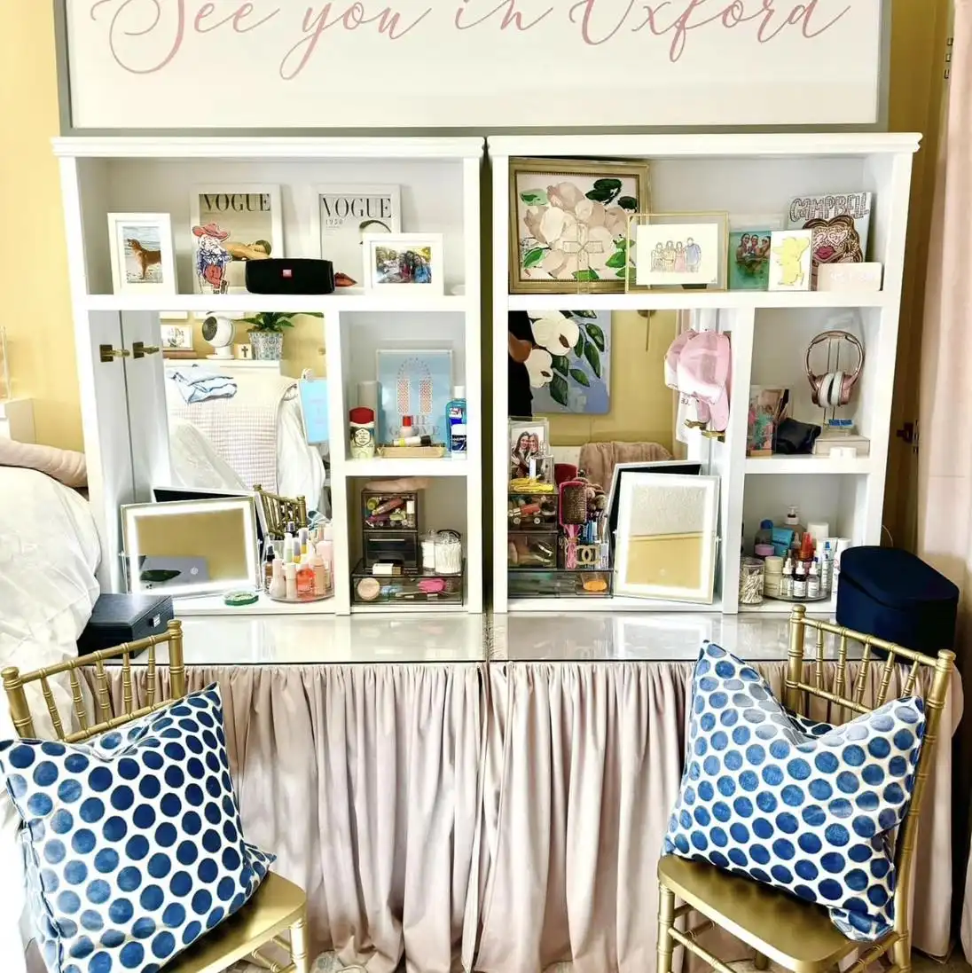 Dorm desk with upper cubby shelves filled with books, frames, mirrors, and personal decor