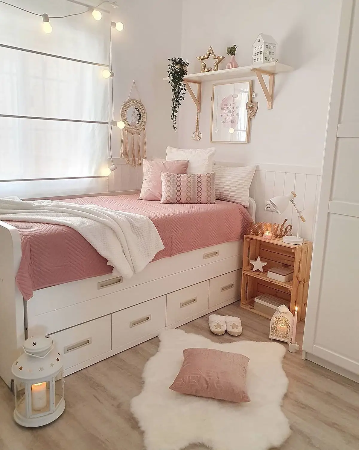 Small bedroom with pink bedding, built-in under-bed drawers, wooden nightstand and wall shelf