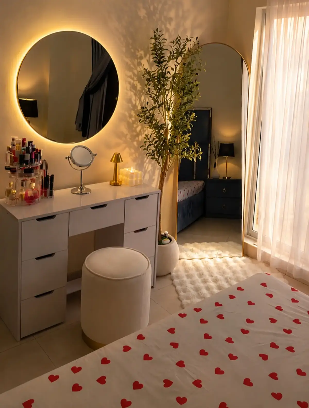 Compact bedroom vanity with round lighted mirror, tall mirror, plant and perfume bottles