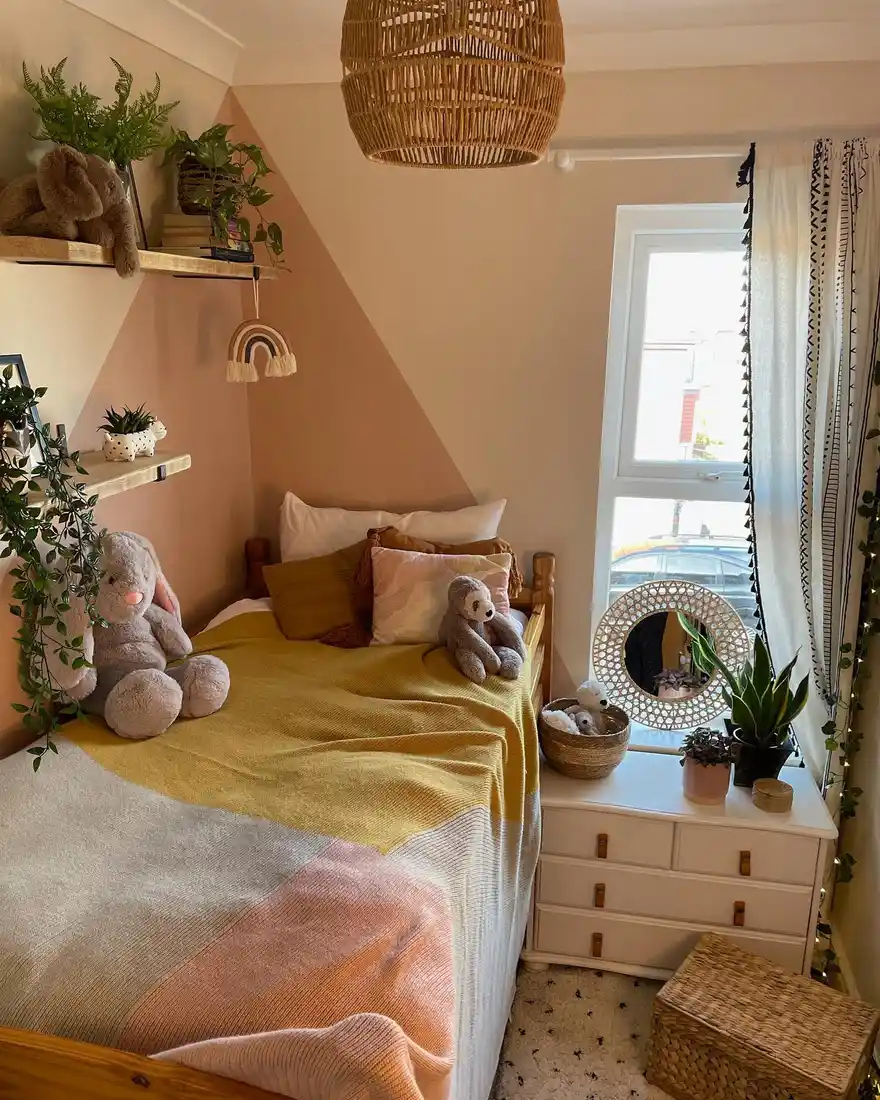 Small kids bedroom with peach painted wall detail, single bed, shelf, and bedside drawers