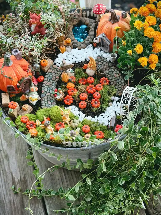 Fairy garden with a winding white gravel path surrounded by colorful orange and yellow flowers