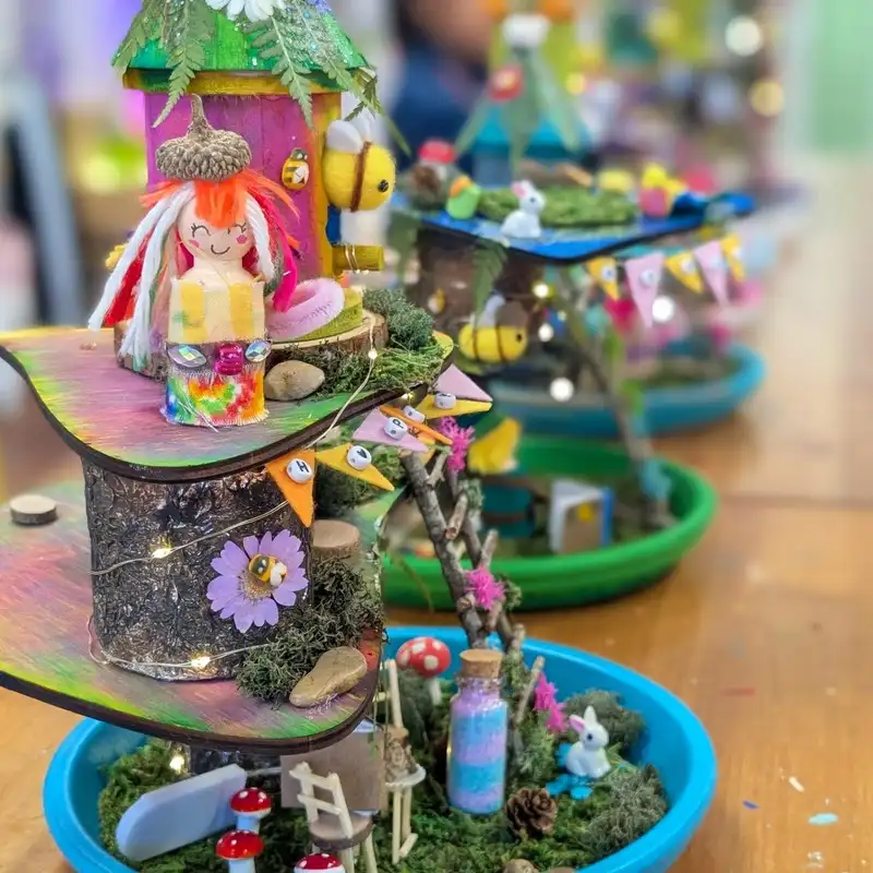 Collection of small colorful fairy gardens arranged in separate miniature pots