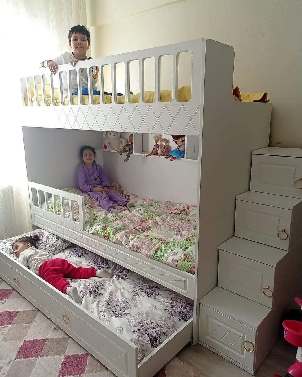 Kids bedroom with bunk beds, pull-out third bed, and storage drawers built into the stairs