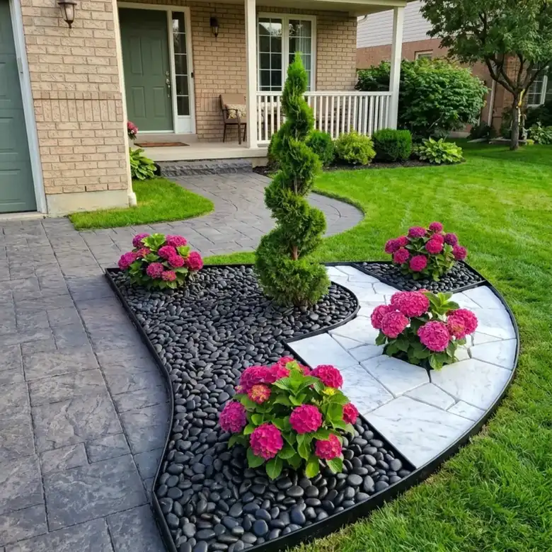 Front flower bed with pink flowers, dark gravel, small evergreen shrubs, and pale stepping stones