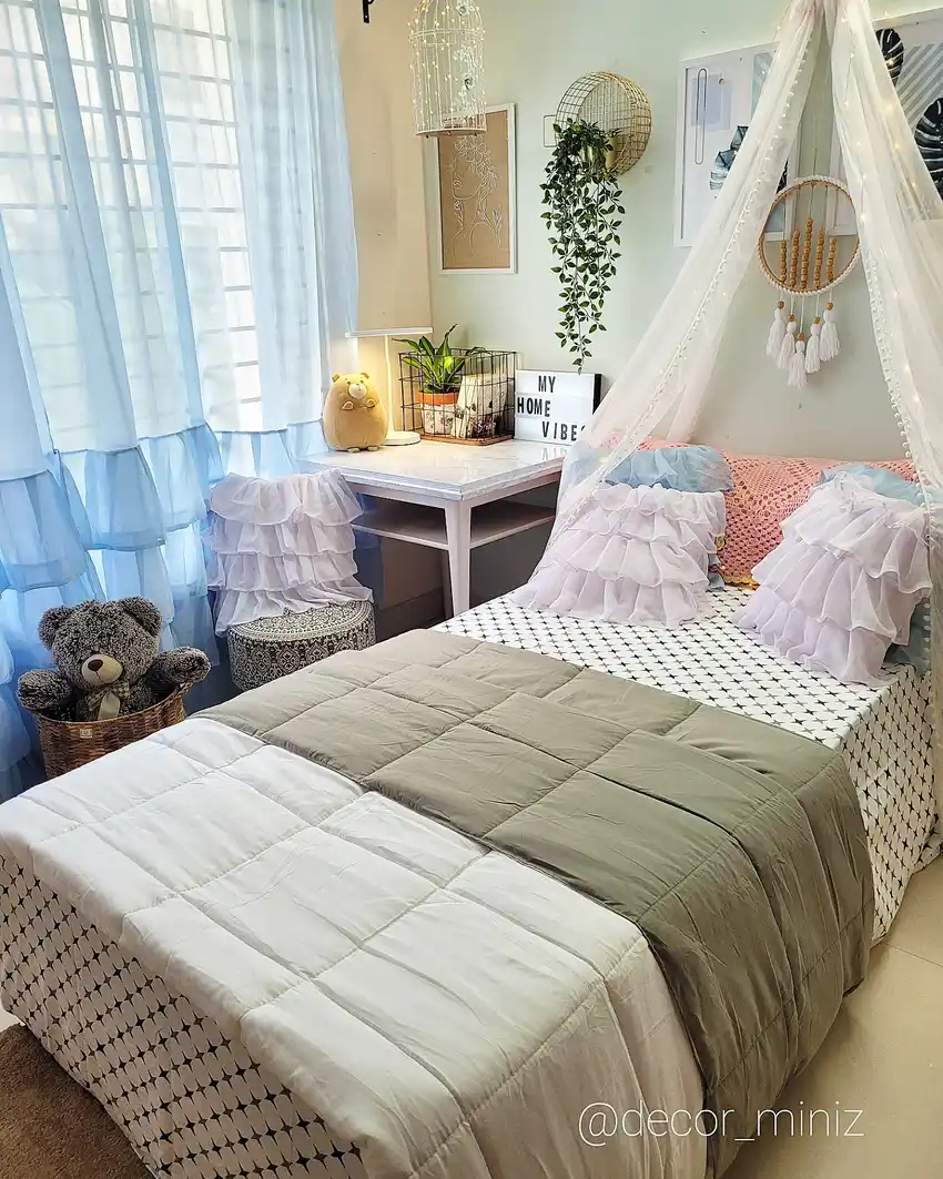Cozy small bedroom with sheer canopy, pale curtains, plants and compact desk area
