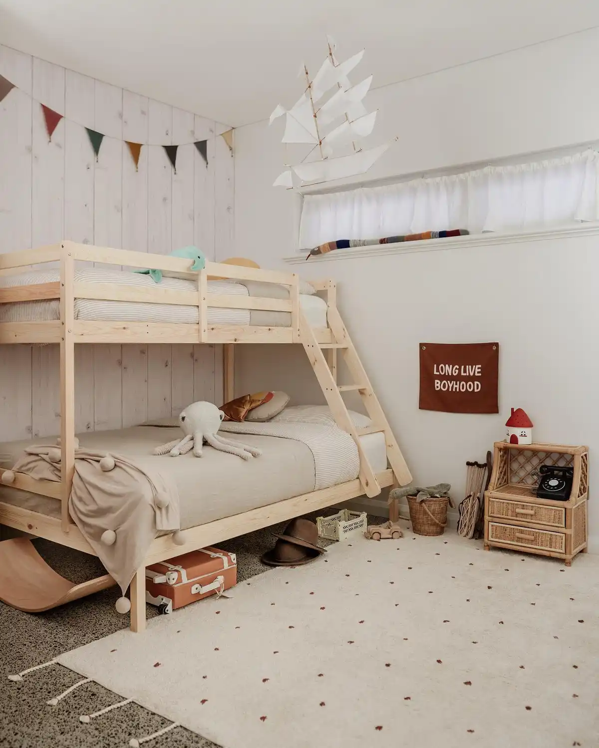 Kids bedroom with low wooden bunk bed and open floor space for play