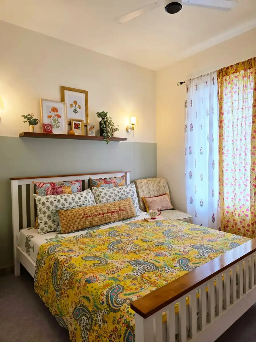 Small bedroom with half-painted accent wall, slim picture ledge and colorful patterned bedding