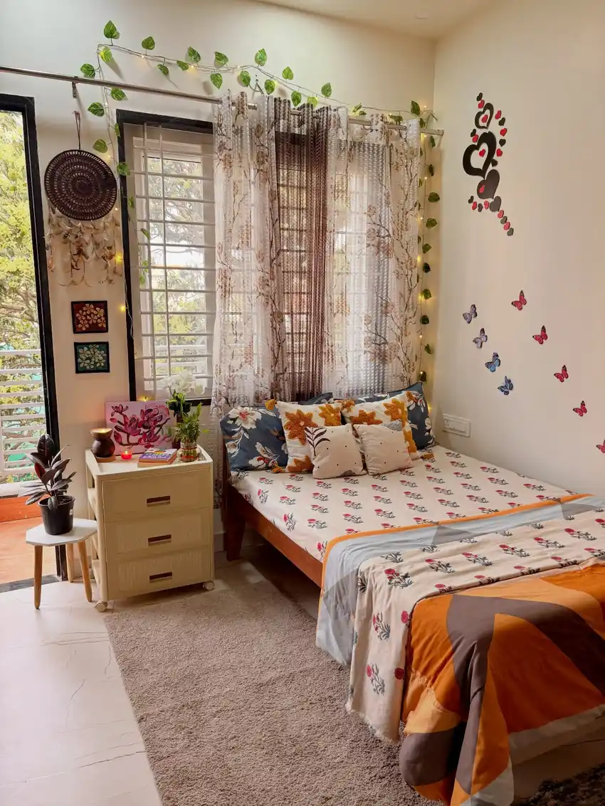 Small bedroom window framed with trailing greenery and butterfly wall decorations