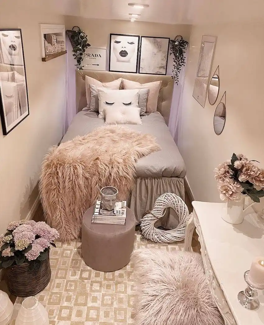 Narrow bedroom with wall mirrors, framed art, hanging greenery and a small vanity area